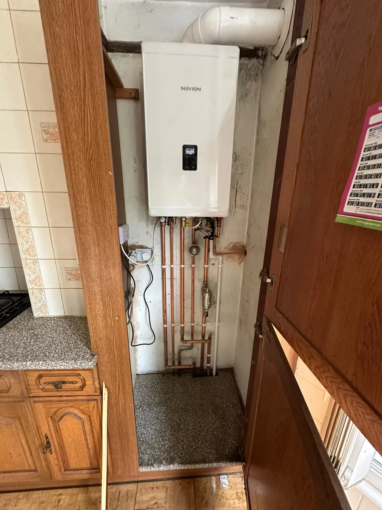 Combi boiler installation in a kitchen cupboard