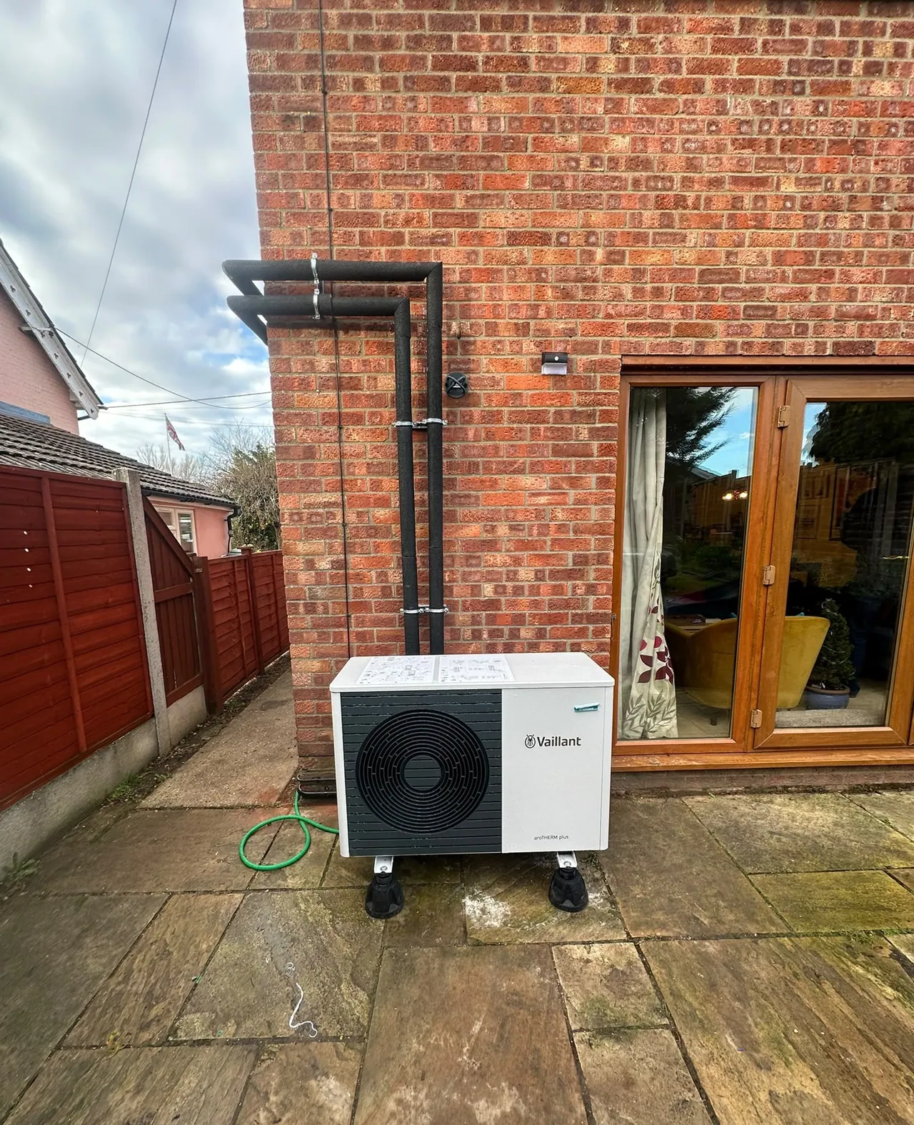 Vaillant air source heat pump outdoor unit beside patio doors