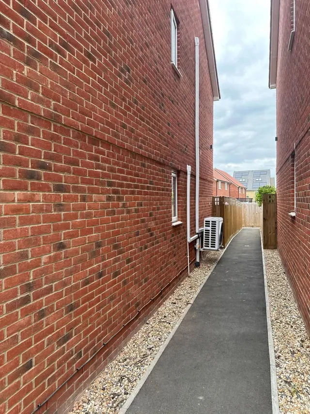 Air conditioning outdoor condenser installed in a narrow paved side passage
