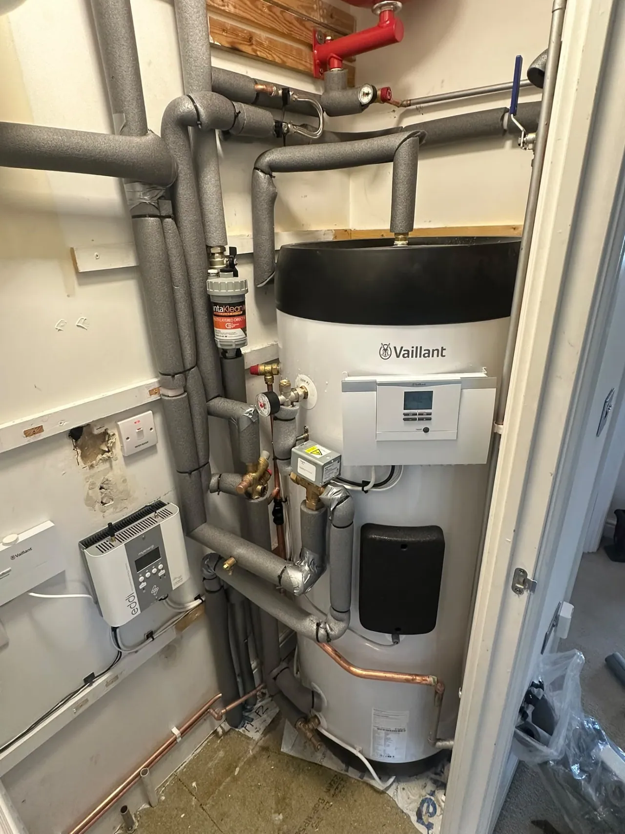 Vaillant heat pump cylinder and insulated pipework in a utility cupboard