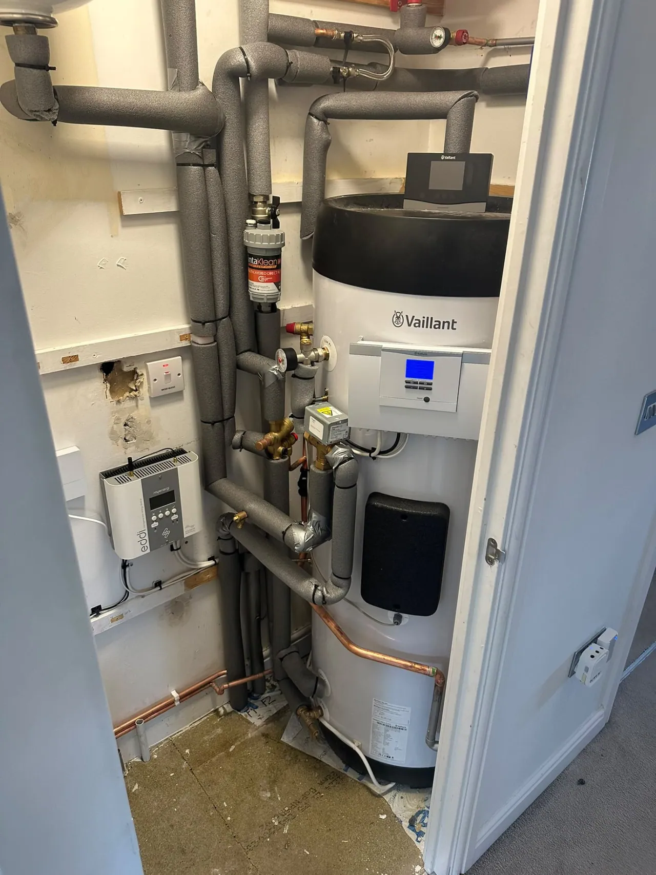 Vaillant heat pump hot water cylinder and insulated pipework in a cupboard