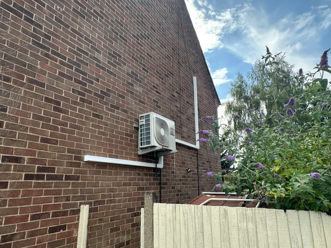 Mitsubishi air conditioning outdoor condenser on a brick wall