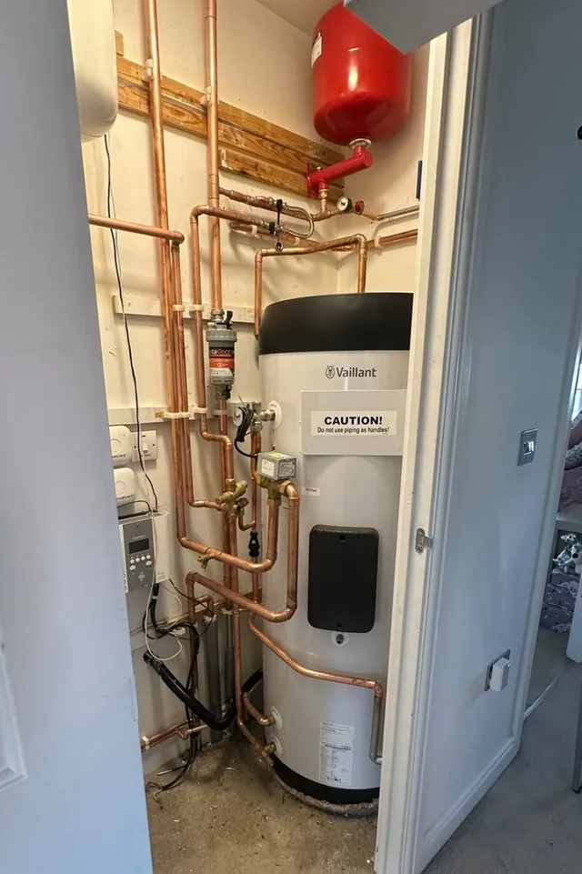 Vaillant heat pump cylinder and pipework installed in a utility cupboard