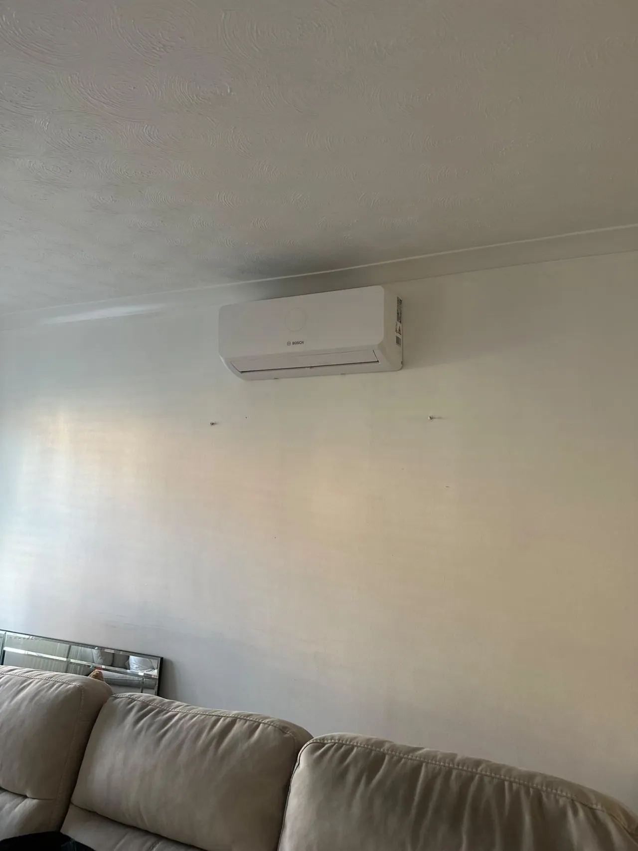 Bosch wall-mounted air conditioning above a sofa