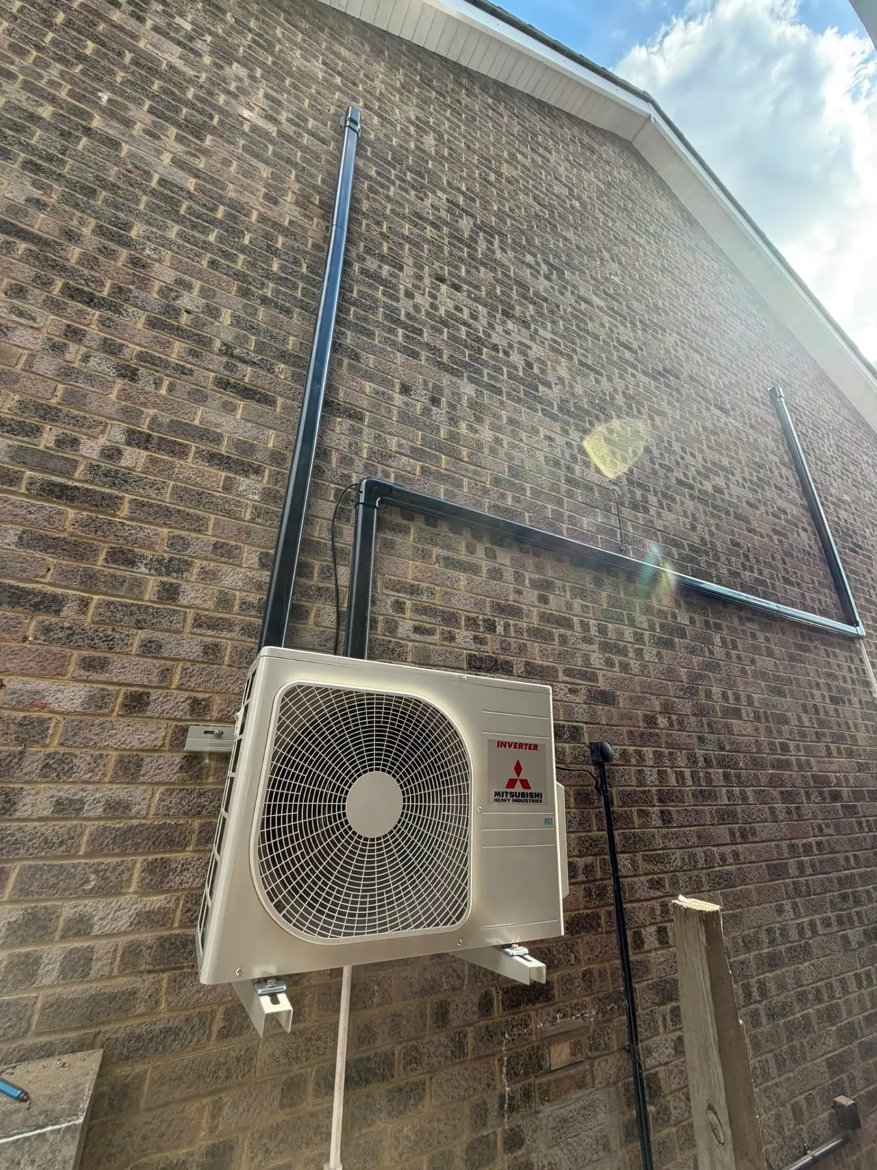Mitsubishi air conditioning outdoor condenser installed with neat black trunking