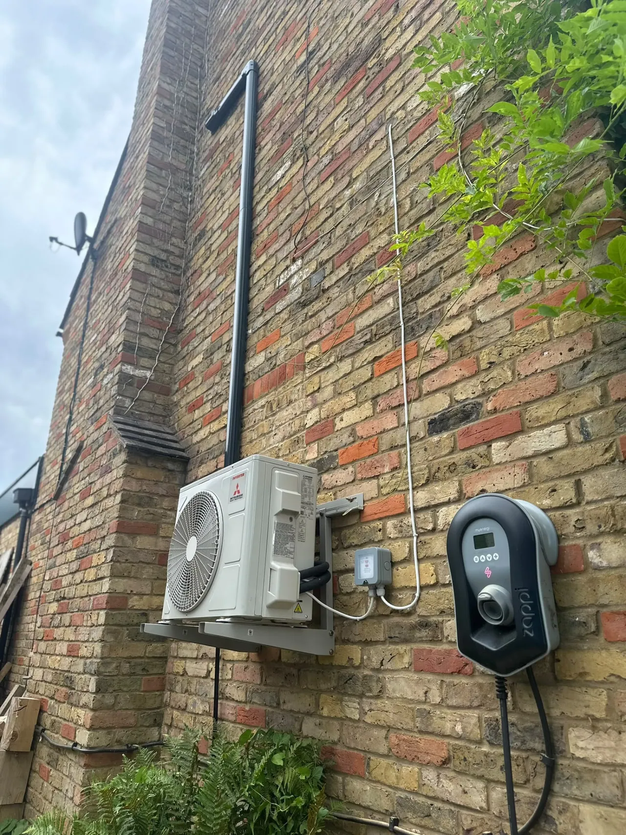 Mitsubishi air conditioning outdoor condenser installed on a brick wall