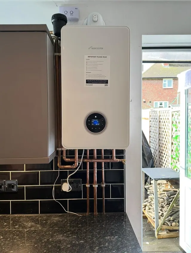 Worcester Bosch boiler installation above black wall tiles