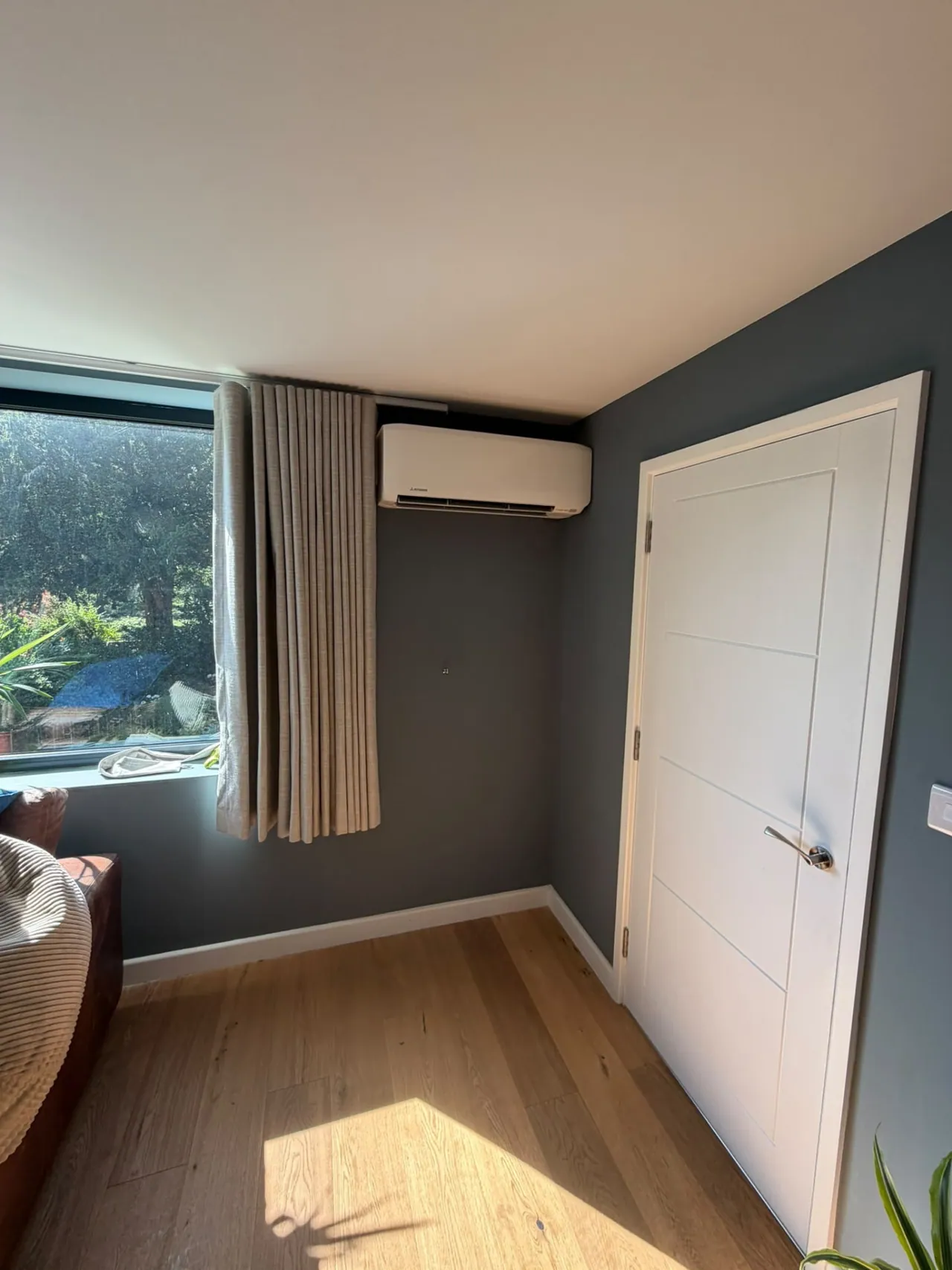 Wall-mounted air conditioning unit installed on a dark feature wall