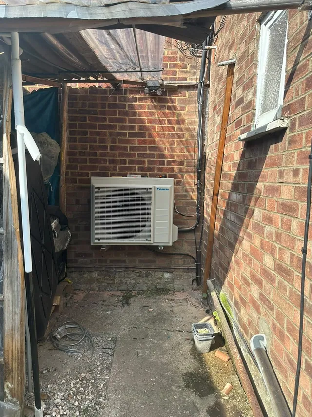 Daikin air conditioning outdoor condenser installed in a narrow side passage