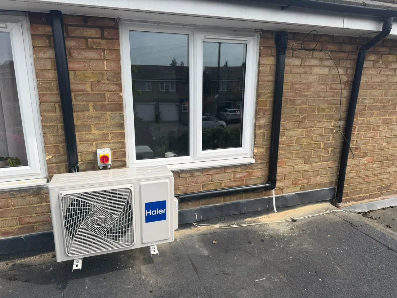 Haier air conditioning outdoor condenser installed below a window