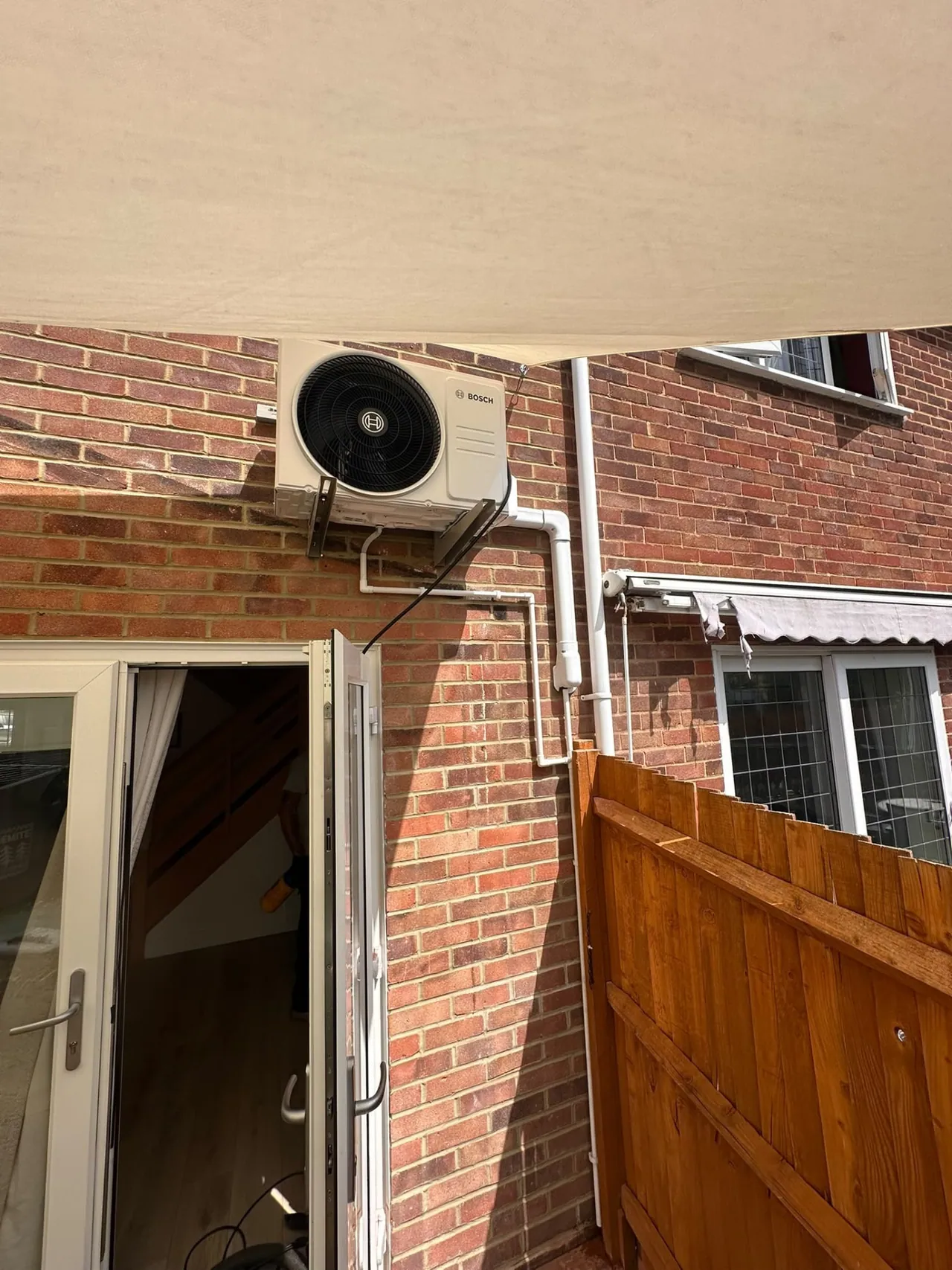 Bosch air conditioning outdoor condenser installed mounted high on a brick wall